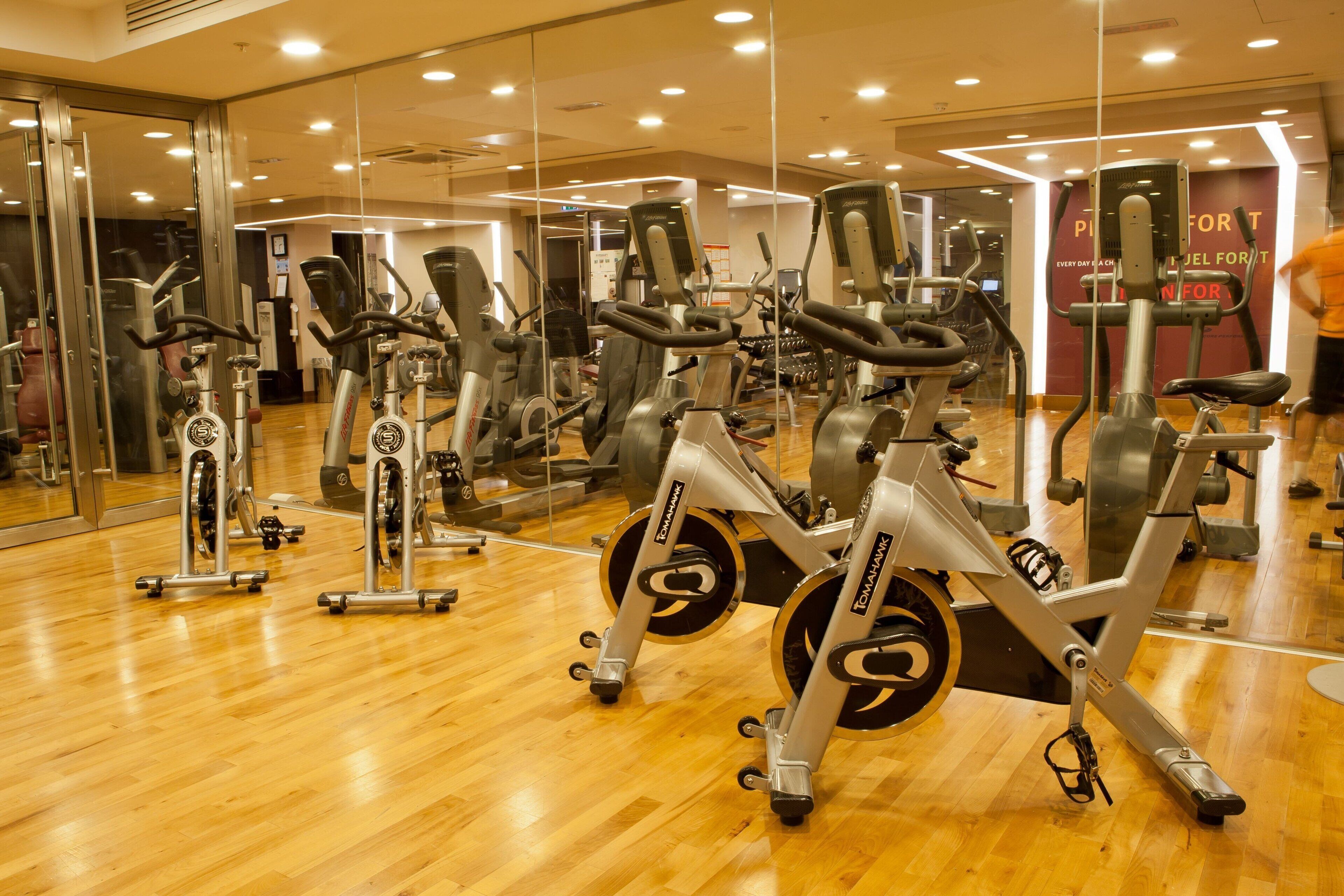 A gym with stationary bikes, mirrors, and exercise equipment.