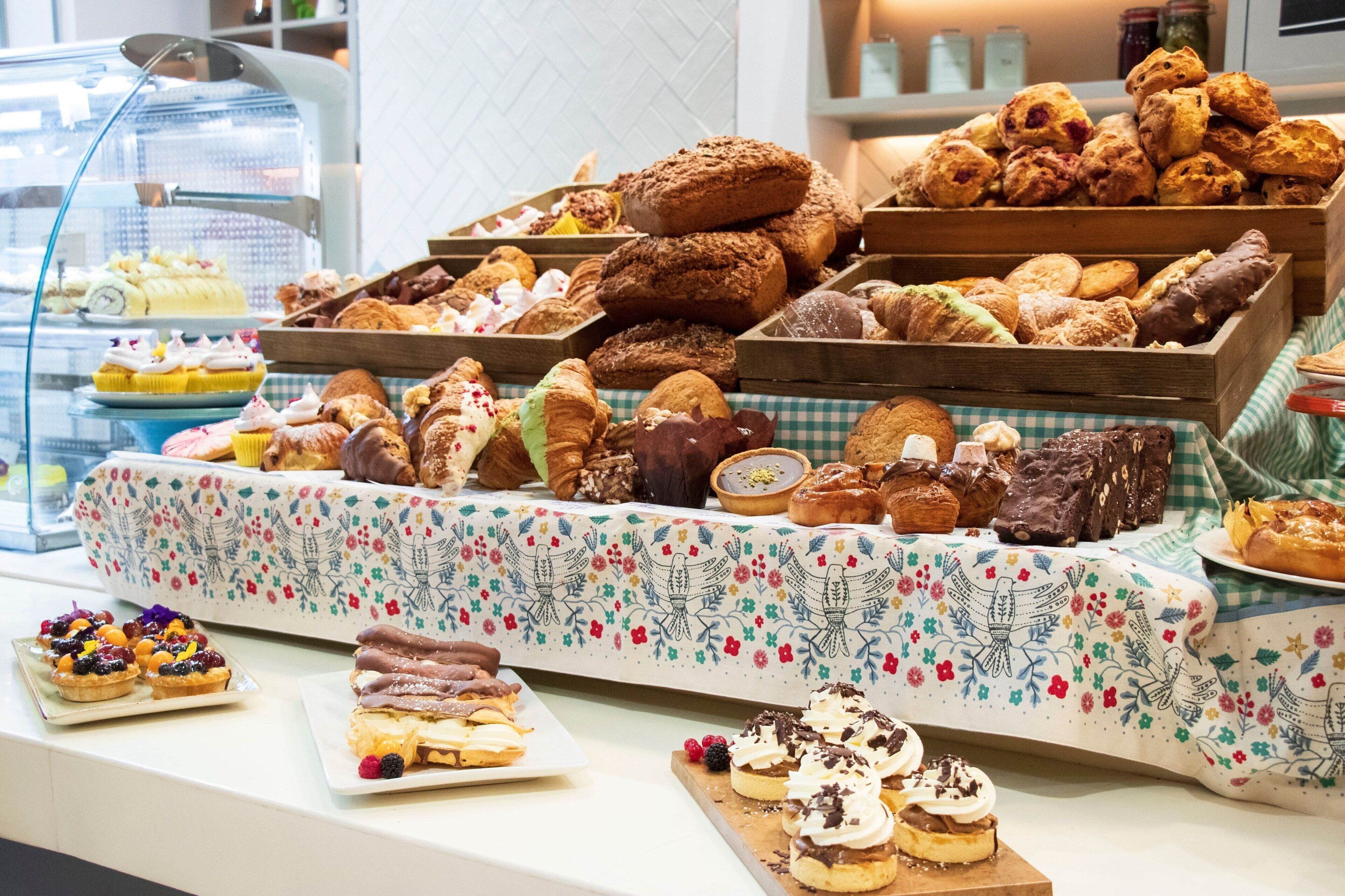 A display of assorted pastries and desserts in a bakery setting.