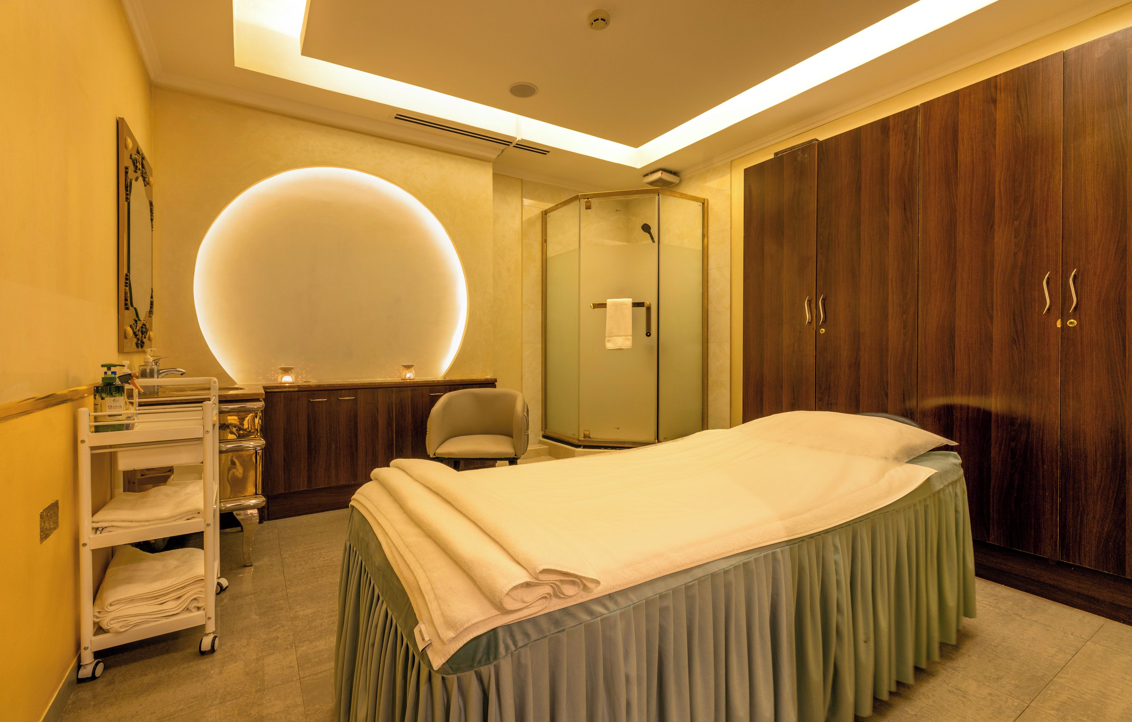 Een hotelkamer met een bed, een kaptafel met spiegel, een douche en een kledingkast.