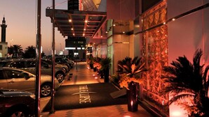 A hotel entrance with a covered walkway, parked cars, and a view of a mosque in the background. - The Eclipse Boutique Suites (Abu Dhabi)