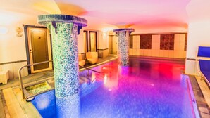 Zona de spa con pilares de mosaico, mostrador de recepción y área de atención al cliente.