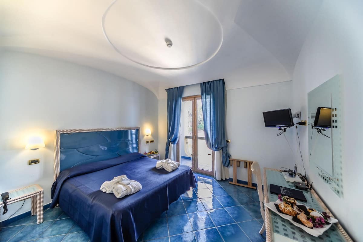 Ein Schlafzimmer mit einem großen Bett, einem Fernseher und einem Frühstücksbrett auf dem Boden.