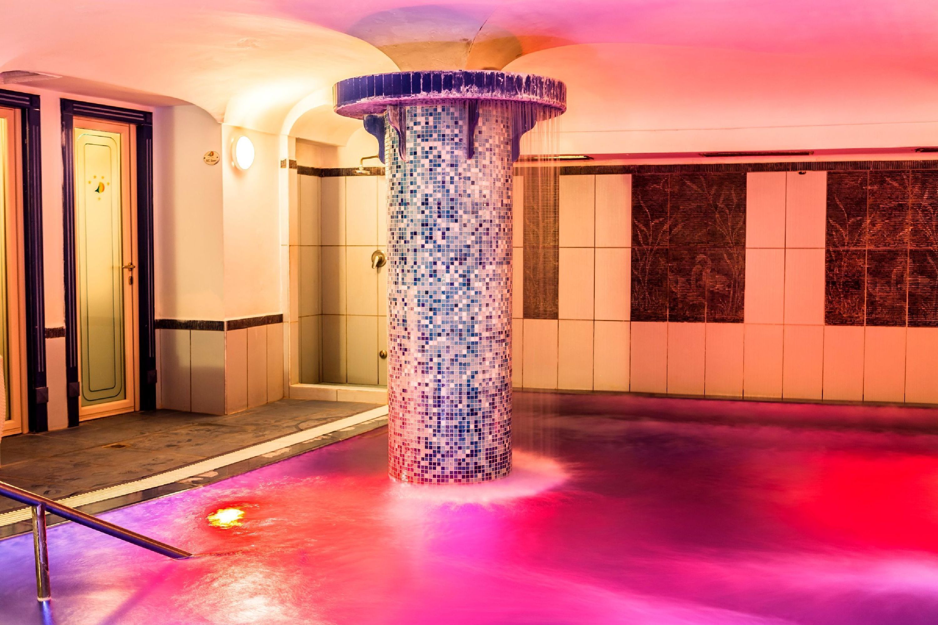 Un área de spa con un columnario de mosaicos, un mostrador de recepción y una puerta.