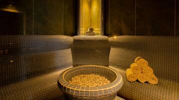 Relax in a serene spa area with a central bowl of bath salts and plush seating.