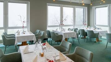 Een restaurant met meerdere tafels klaar voor diners, elk met stoelen en servies.