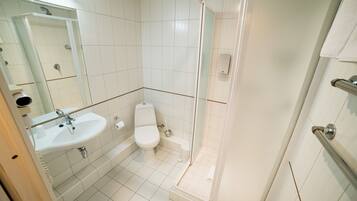 Een badkamer met een wastafel, toilet en douchecabine.