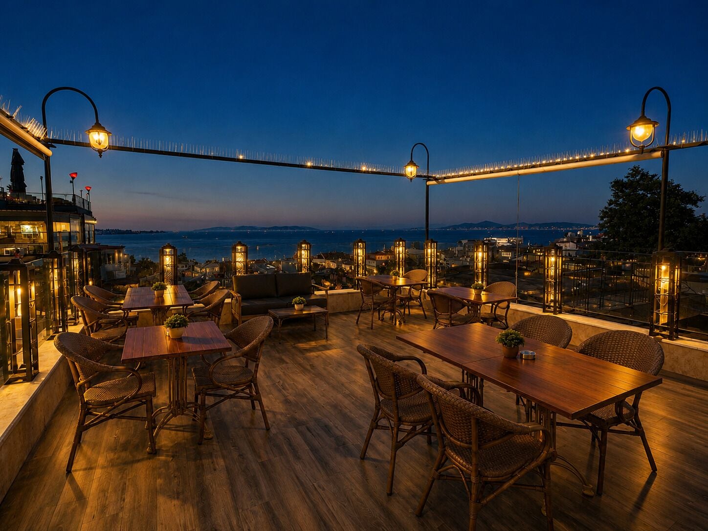 An outdoor terrace with wooden flooring, wicker furniture, and string lights.