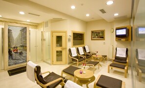 Une salle de spa équipée de fauteuils de massage, d’un sauna et d’un téléviseur.