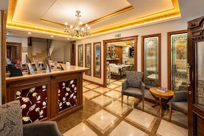 A hotel lobby with a reception desk, seating area, and a view of the dining area. - GLK PREMIER Regency Suites & Spa - Special Class (Istanbul)