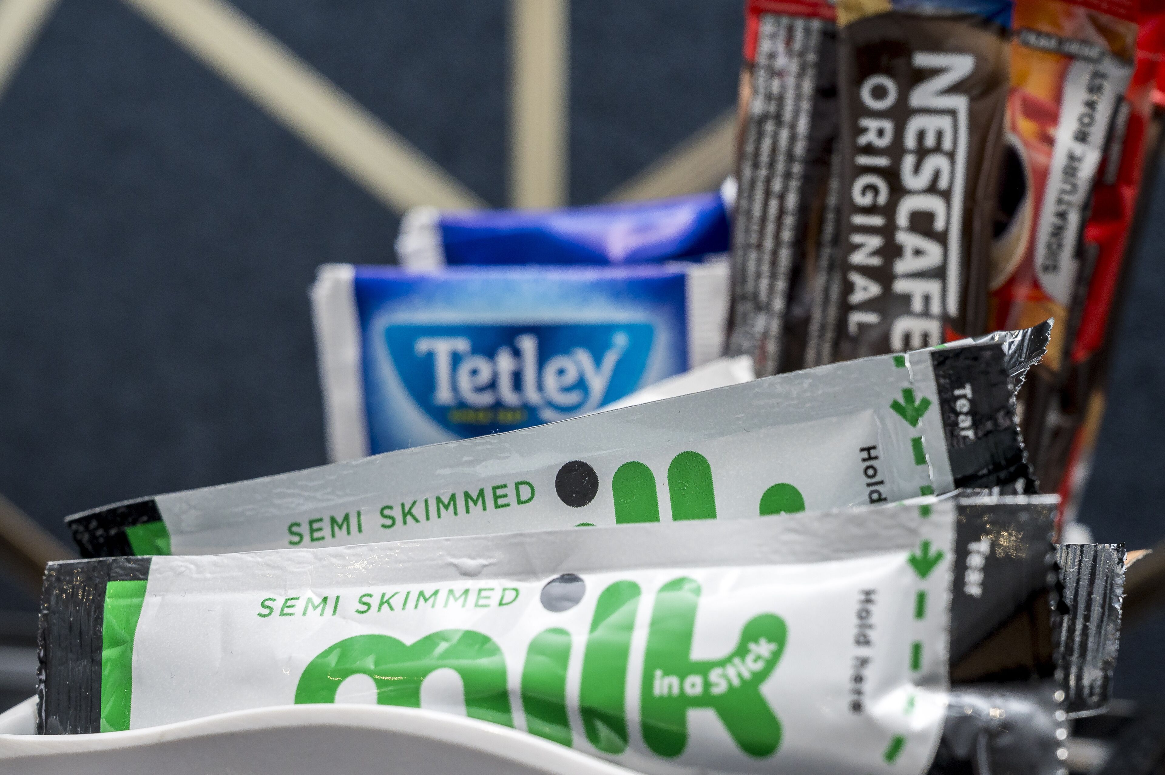 A collection of snack packages including Tetley tea, Nescafé Original, and semi skimmed milk.