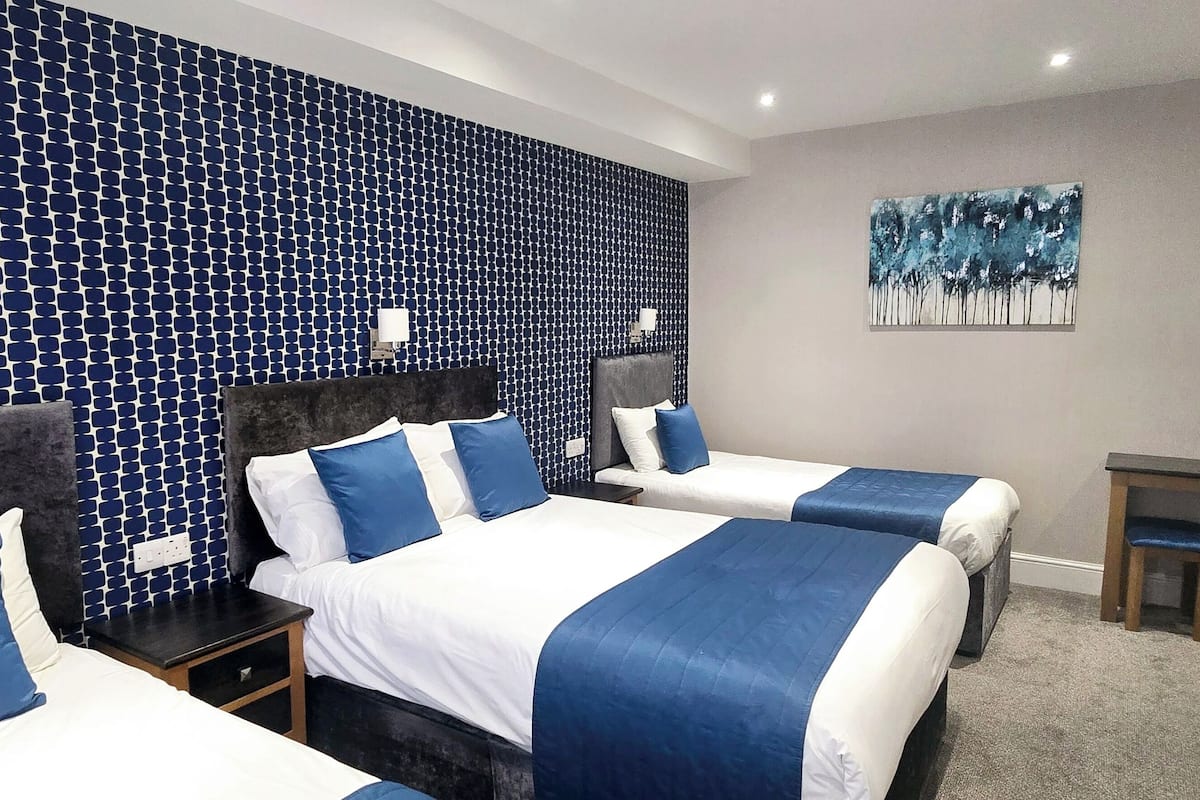 Habitació d'hotel amb dos llits, una taula de treball i un quadre a la paret.