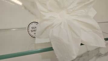 A white towel with a bow on a marble surface.