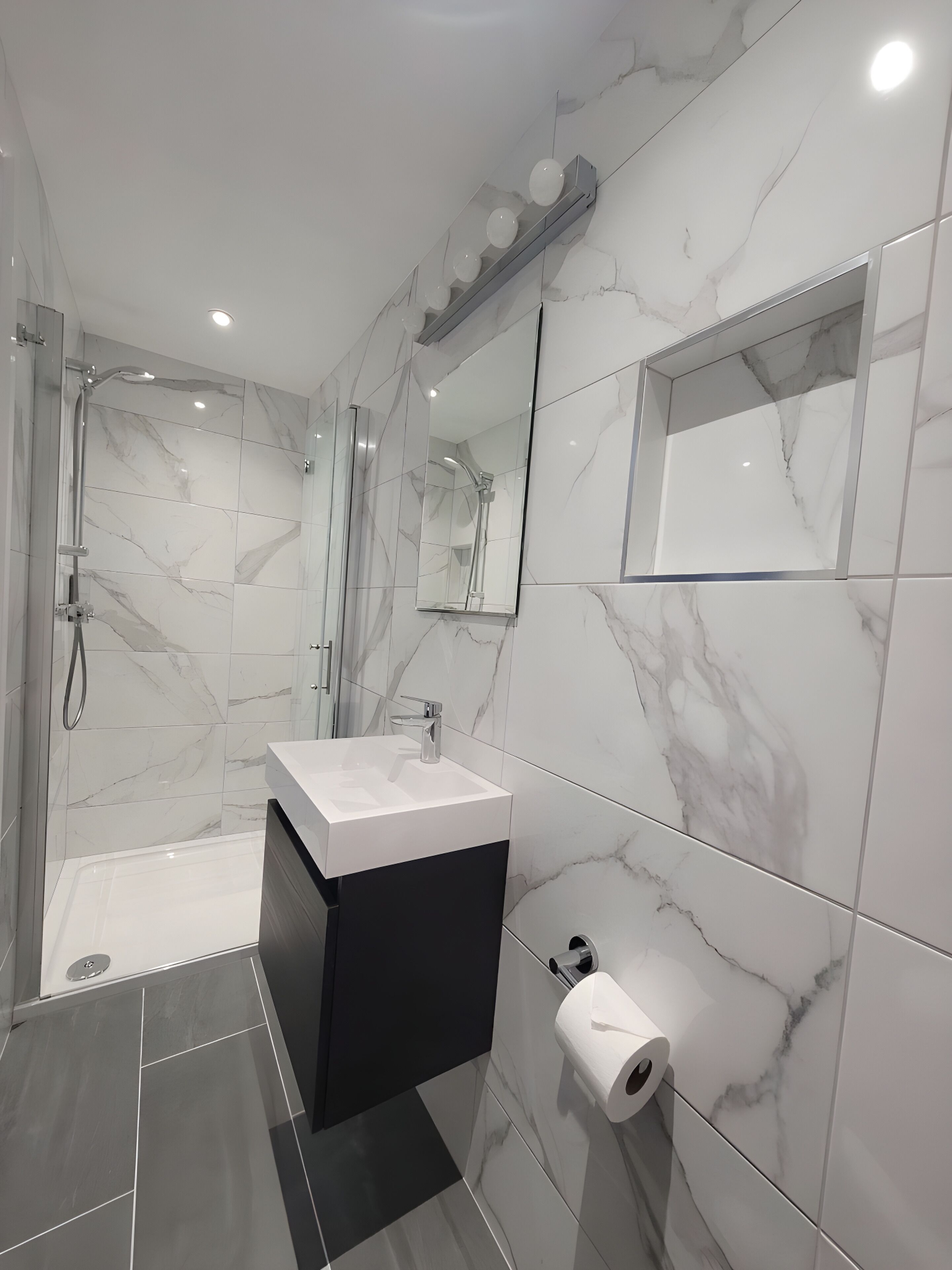 A modern bathroom with a shower, a sink, and a toilet.