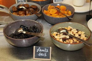 A variety of bowls containing different food items, with a sign indicating 'fruits secs' in the foreground.