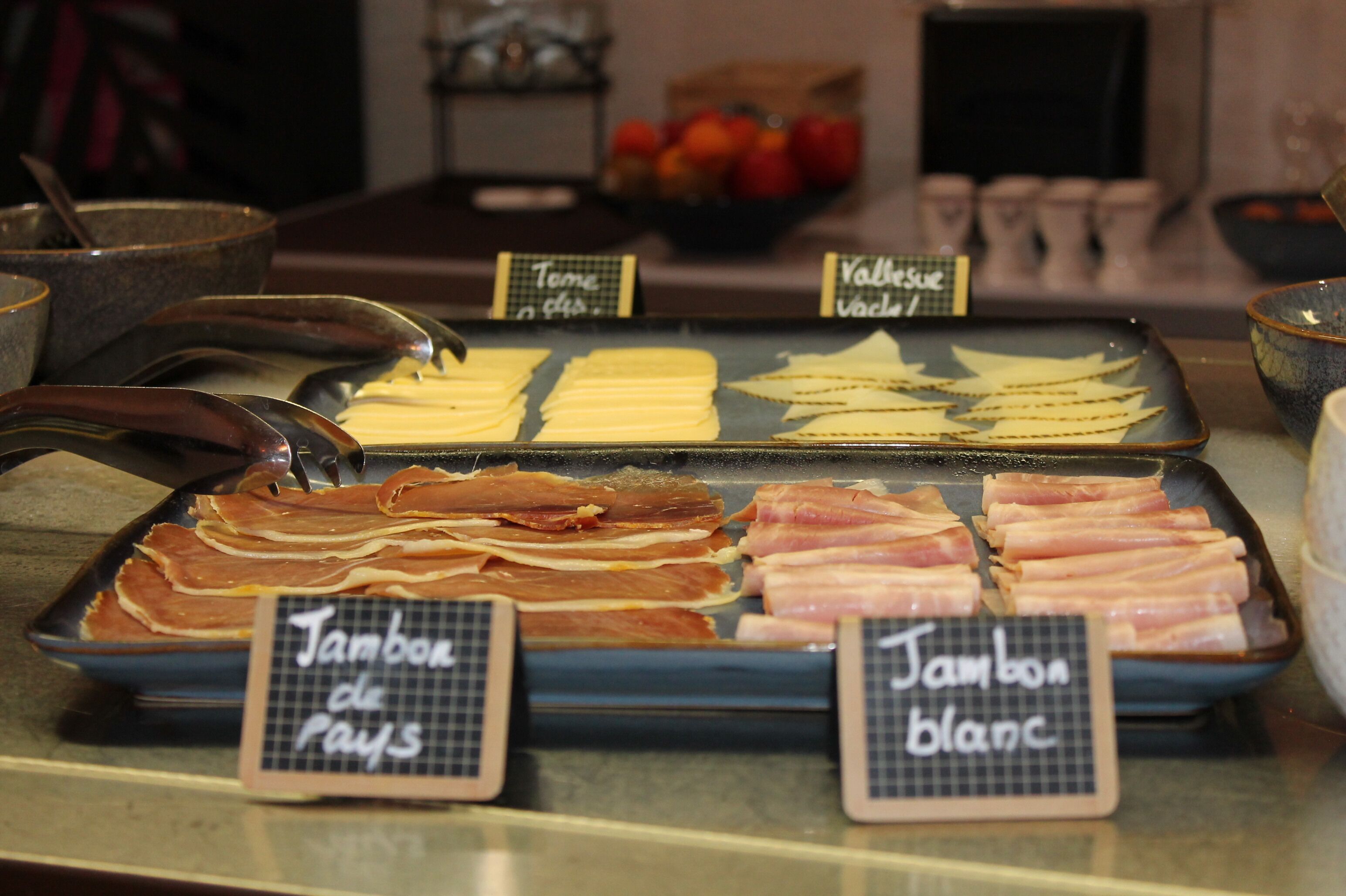 A selection of meats and cheeses at a deli counter.