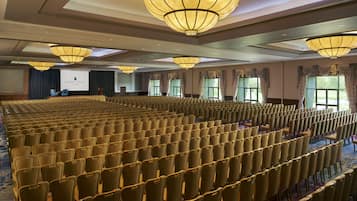 A conference room with rows of chairs, a podium, and a presentation screen.