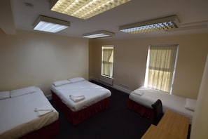 A room with two single beds, a desk, and a chair. - York Hotel (Ilford)