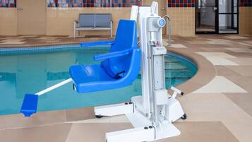 A pool area with a blue chair and a water slide.