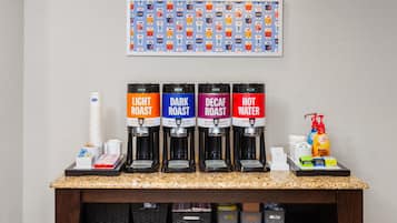 A coffee station with four dispensers labeled Light Roast, Dark Roast, Decaf Roast, and Hot Water.