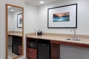 Casa de banho com lavatório, espelho e uma moldura com imagem na parede.