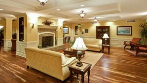 A spacious lobby with a fireplace, comfortable seating, and elegant lighting fixtures. - Homewood Suites by Hilton Charleston Airport (North Charleston)