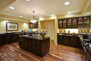 Una cocina amplia con armarios de madera oscura, una isla central con electrodomésticos y un ventanal que proporciona luz natural.
