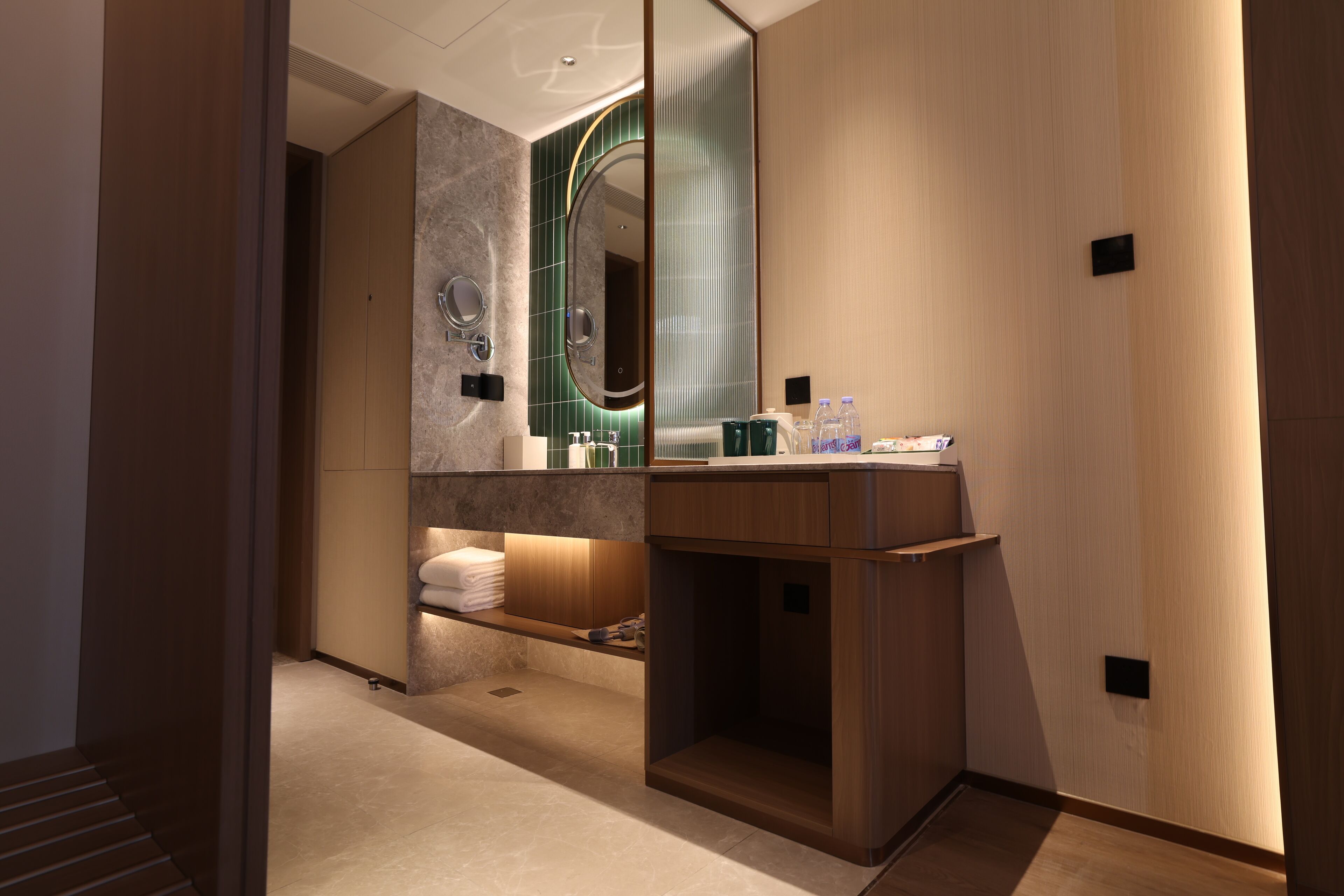 Un baño moderno con tocador, espejo y perchero.