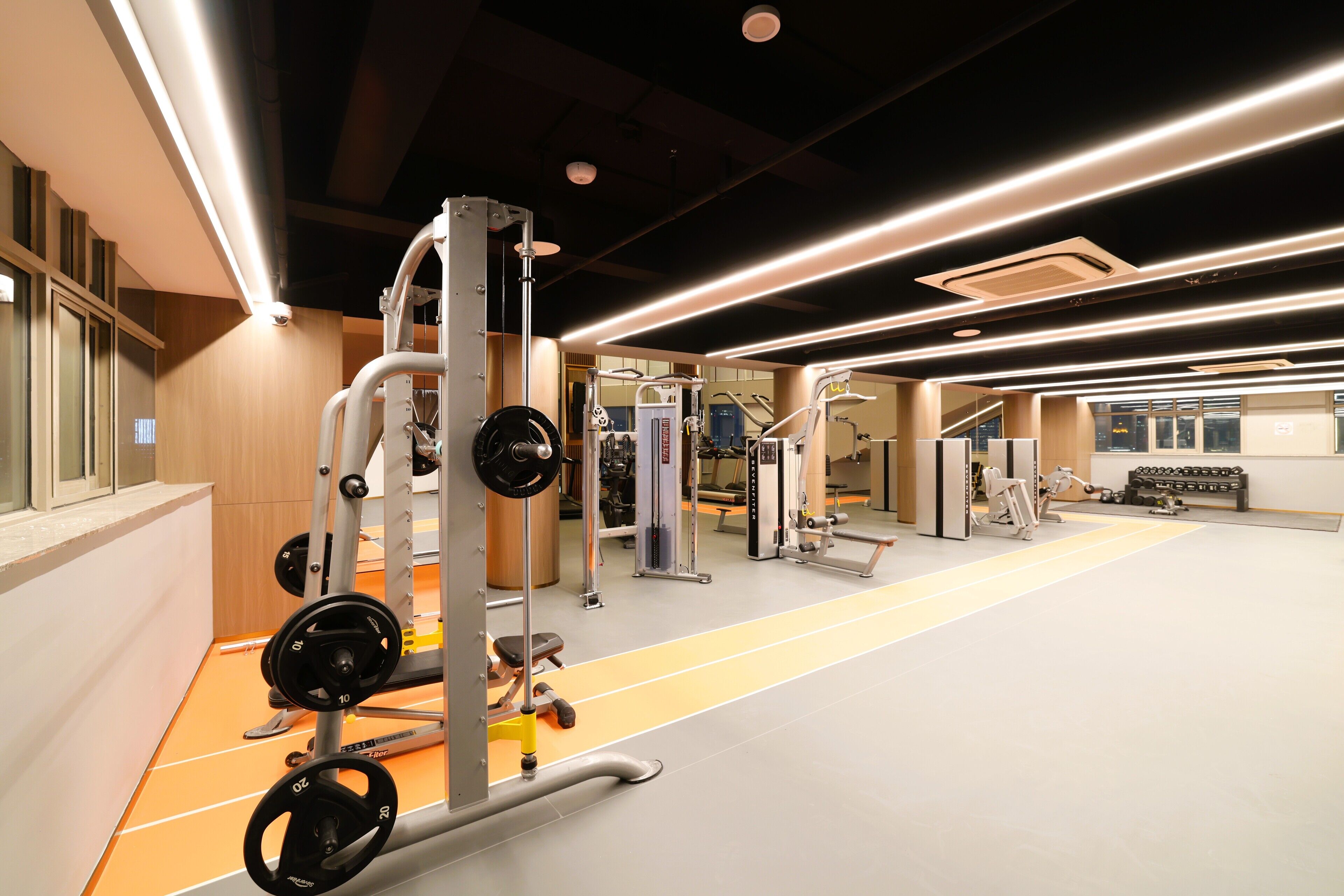 A gym with weightlifting equipment, cardio machines, and a track.