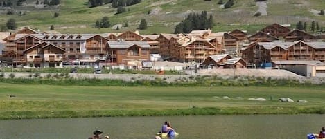 A lakeside lodge with wooden cabins and a group of people in a green canoe.