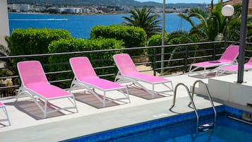 Alberca al aire libre y camastros