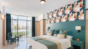 Habitación de hotel con una cama grande, un escritorio y vistas al exterior.