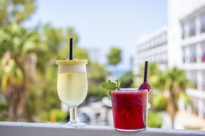 Two drinks on a balcony with a view of palm trees and buildings. - The Palm Star Ibiza - Adults Only (Sant Josep de sa Talaia)