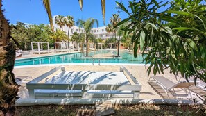 A pool area with lounge chairs and palm trees. - The Palm Star Ibiza - Adults Only (Sant Josep de sa Talaia)