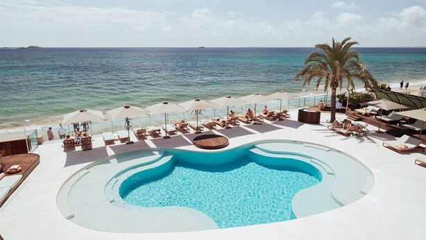 A pool area with lounge chairs and umbrellas, overlooking the sea. - AMA Ibiza Suites - Adults Only (Sant Josep de sa Talaia)