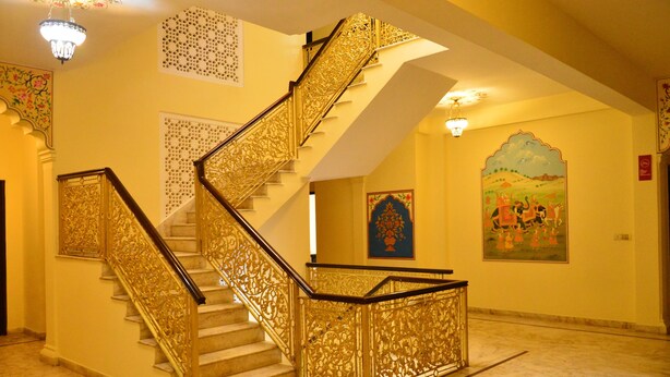 A grand staircase with ornate golden railings and a marble floor. - Hotel Amer View (Amer)