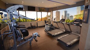 Un gimnasio moderno con cintas de correr, elípticas y equipamiento de levantamiento de pesas.