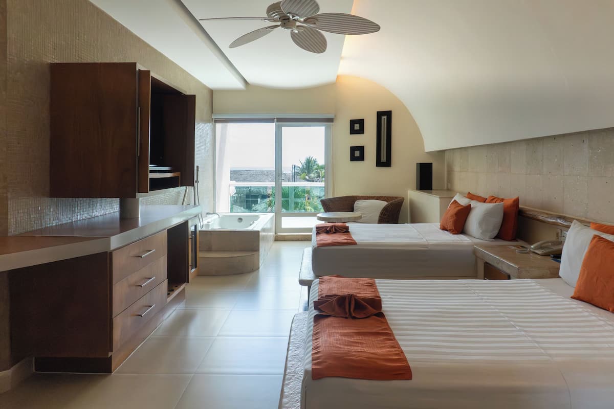 Una habitación de hotel moderna con una cama grande, un escritorio, una silla y un balcón con vistas.