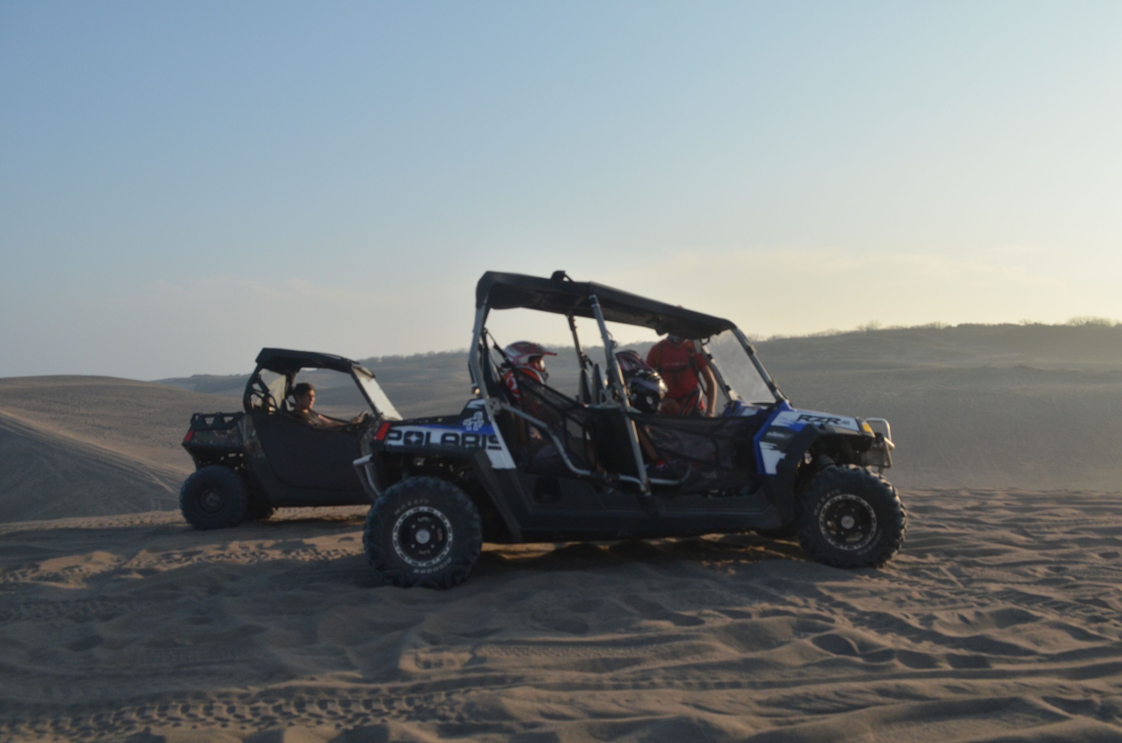 Two off-road vehicles on a sandy terrain.