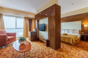 Una habitación de hotel con cama, televisión, escritorio y silla.
