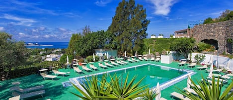 Een binnenzwembad, een buitenzwembad, ligstoelen bij het zwembad