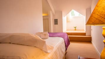 Un dormitorio con cama, ventana, escalera y lámpara.