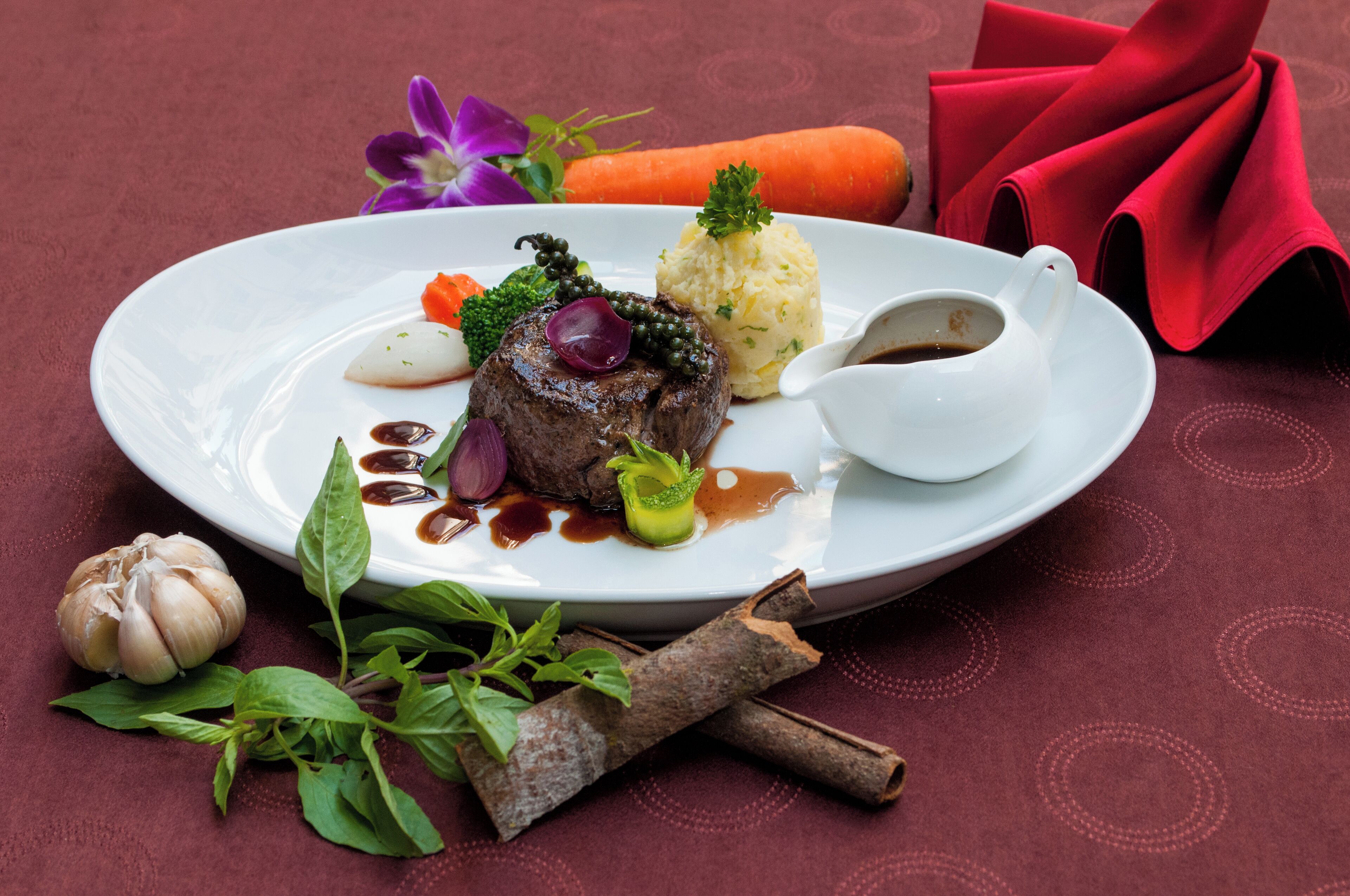 Une assiette de nourriture comprenant un plat de viande, de la purée de pommes de terre et des légumes.