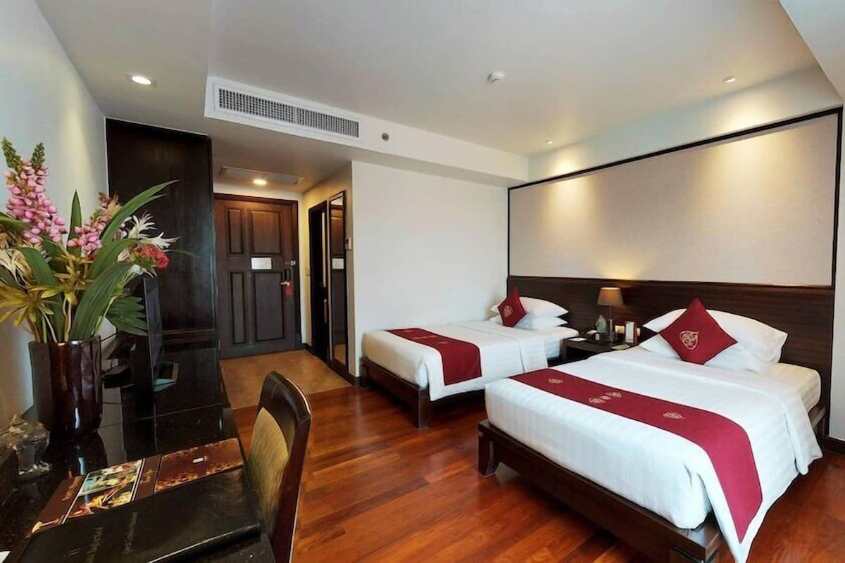 Una habitación de hotel con dos camas, un escritorio y una silla.