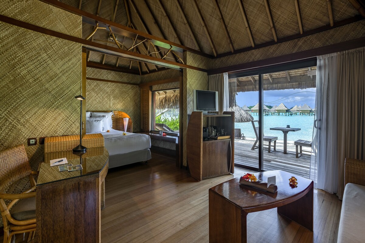Ein Hotelzimmer mit Bett, Schreibtisch, Fernseher und Meerblick.