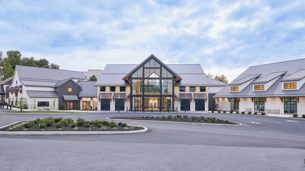 A modern building with a central glass facade and symmetrical design, featuring multiple entry points and a landscaped driveway. - Hersey Farm Resort  (Ronks)