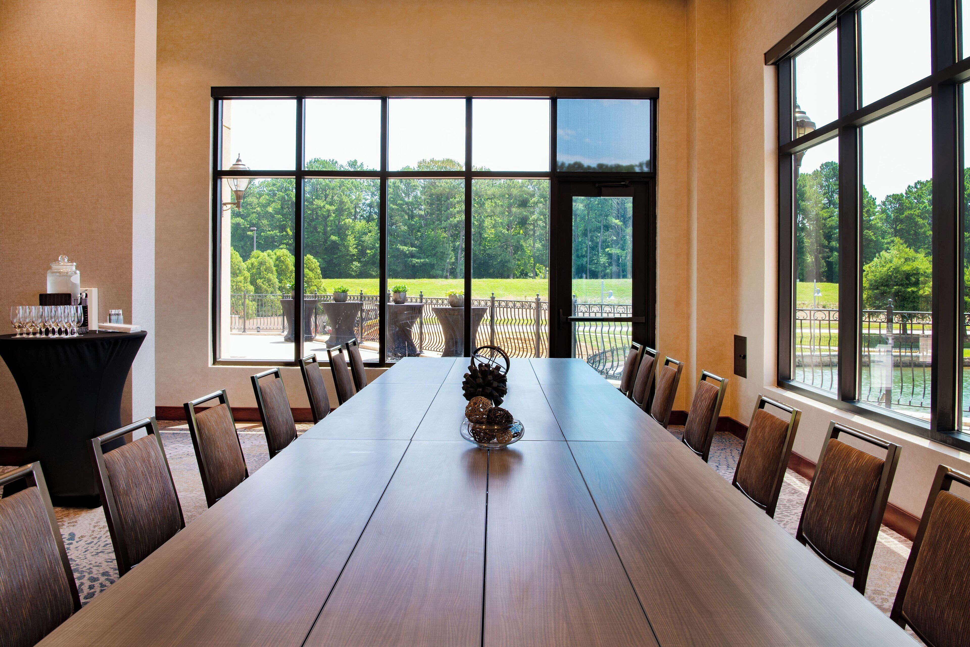 Une salle de conférence équipée d’une longue table, de chaises et d’un buffet garni de divers plats.