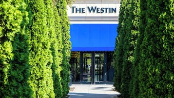 A building entrance with a blue awning and the sign "The Westin".