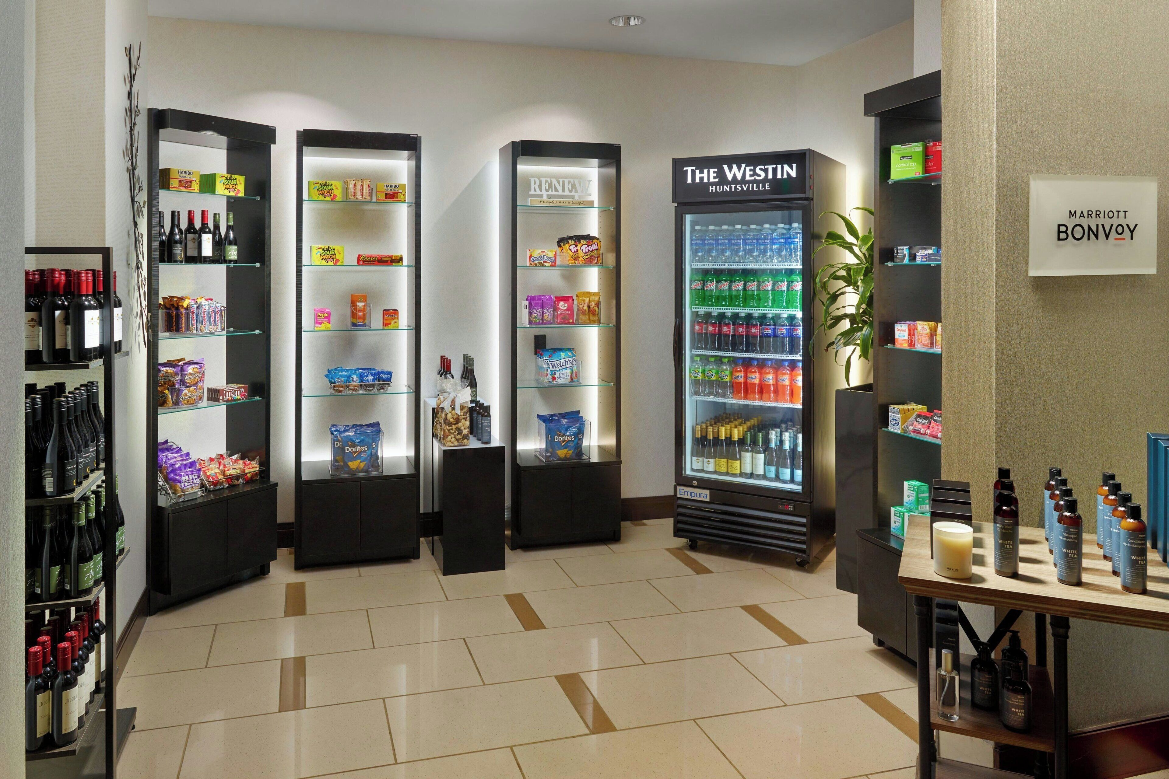 Een hotellobby met een wijnkoeler, snacks en een minibar.
