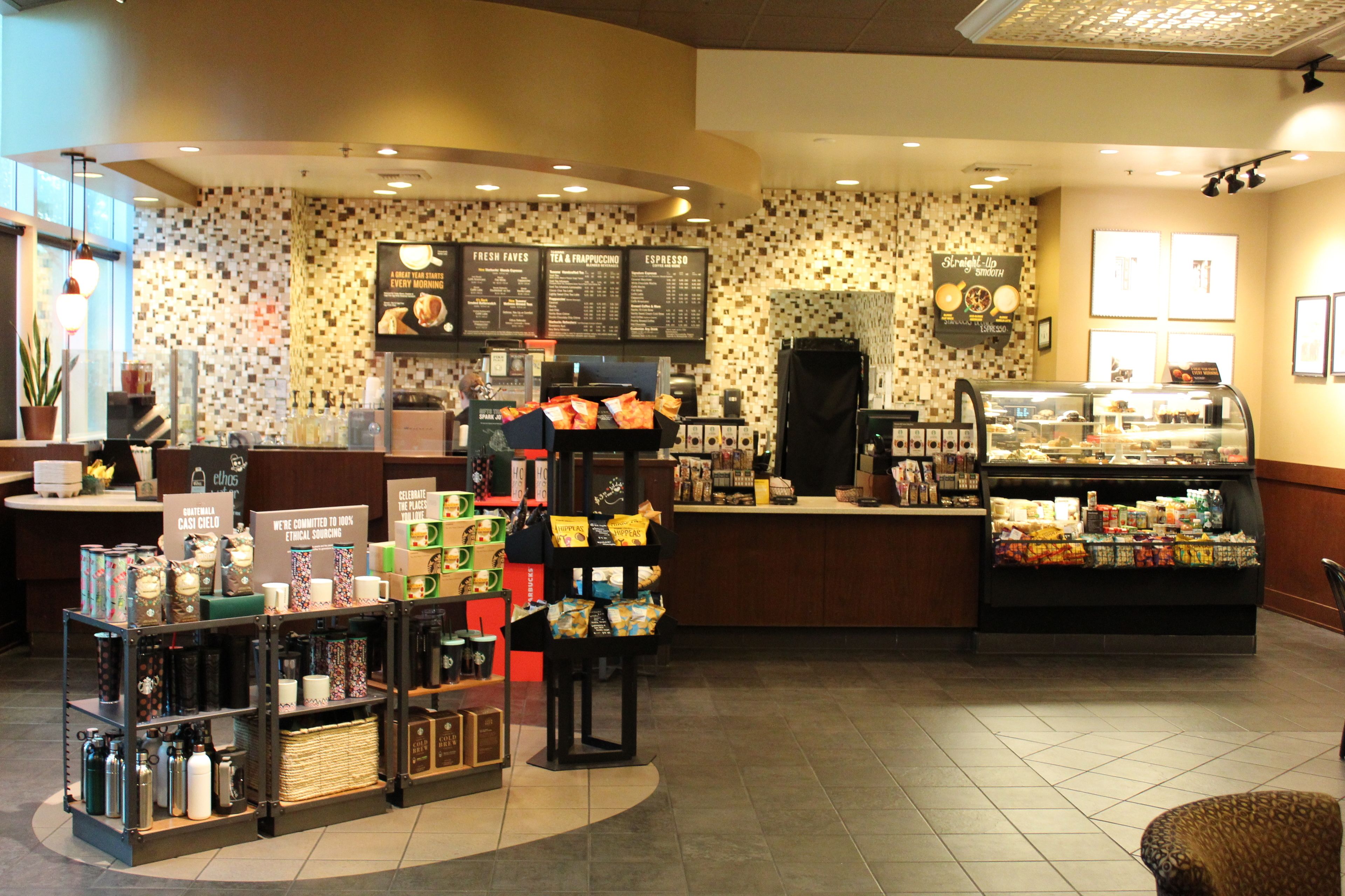 A coffee shop interior with a counter, menu boards, and a display case.