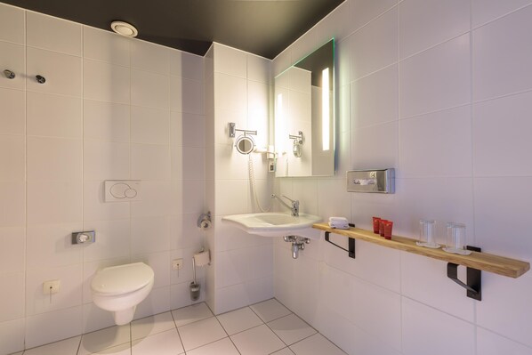 A modern bathroom with a toilet, sink, and mirror.